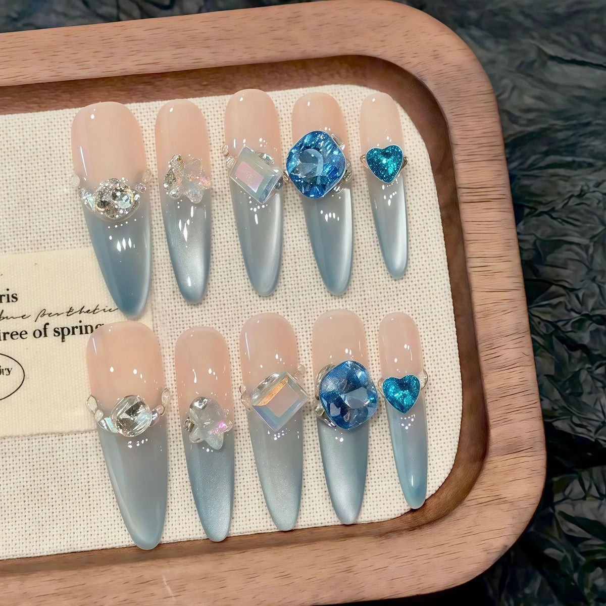 Blue Danube 10-piece handmade press-on nail set displayed on wooden tray - product flat lay