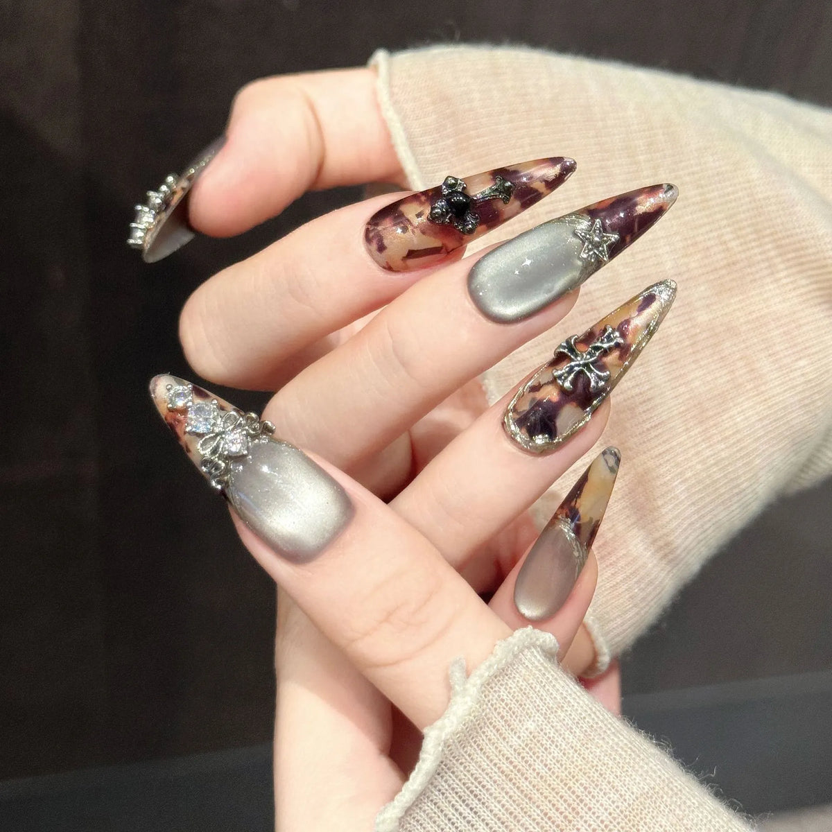 Antique Relic stiletto nails angled view showing brown shimmer gradient and vintage metallic details