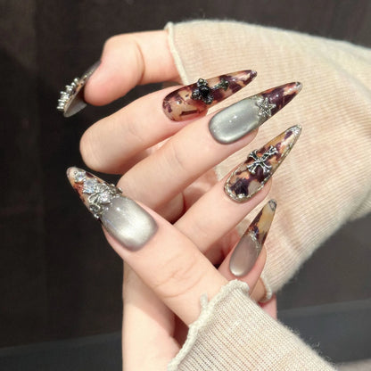 Antique Relic stiletto nails angled view showing brown shimmer gradient and vintage metallic details