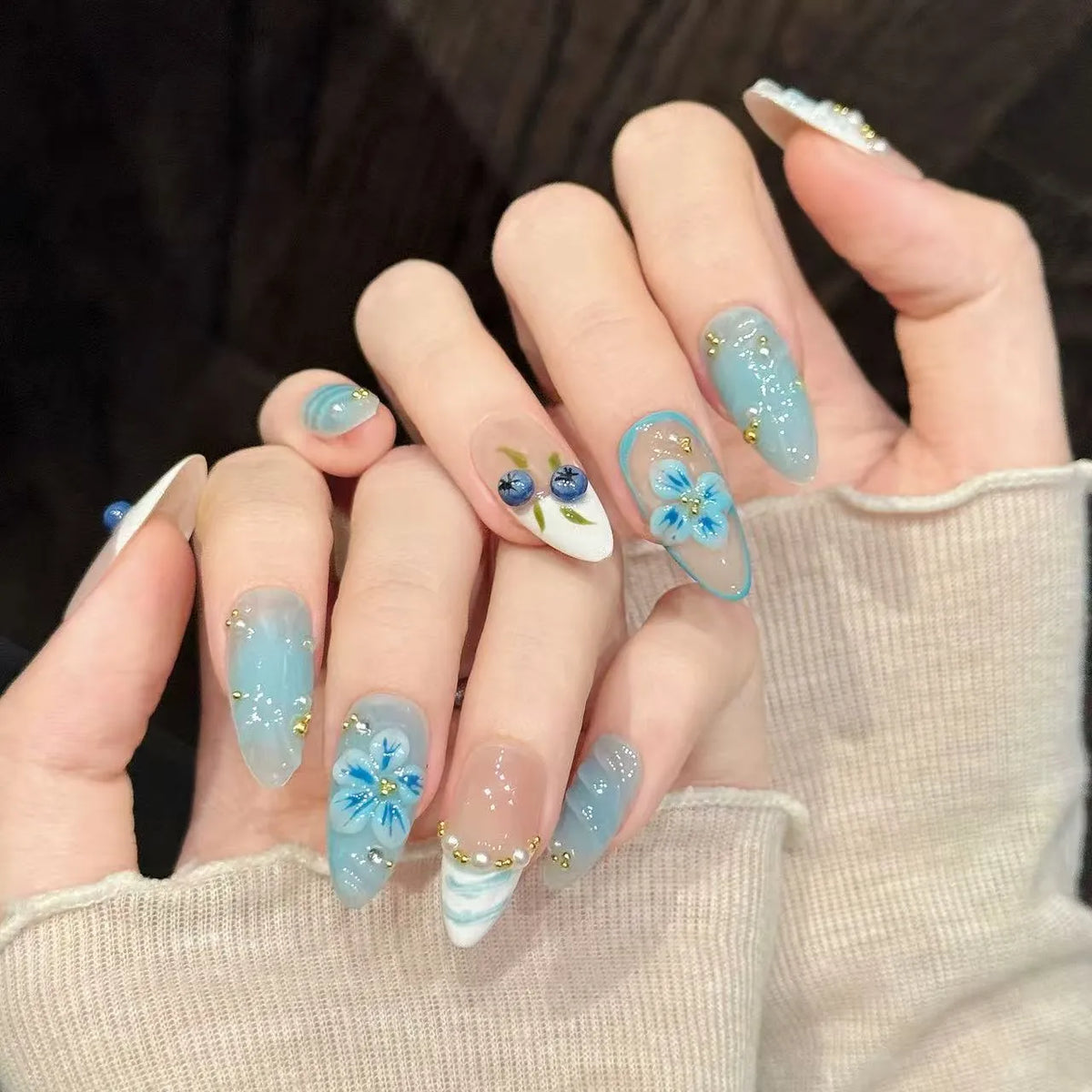 Blue Berry oval nails angled view showing cool blue ombre and delicate berry art 💙