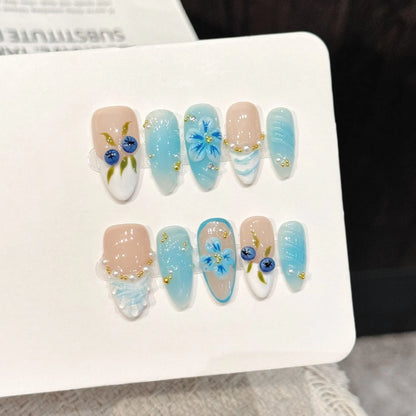 Blue Berry long oval press-on nails with ice blue gradient hand-painted blueberry design on hand - lifestyle shot 🫐💙