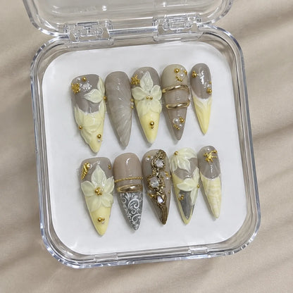 Buttercream Fleur handmade Long Stiletto nail set arranged in a clear presentation case