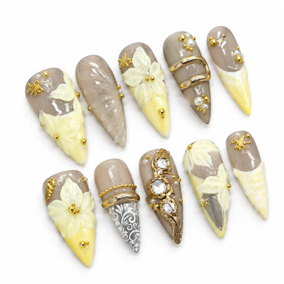 Detailed view of NM-A040 Long Stiletto nails with crystal jewelry gold curves and ornamental linework