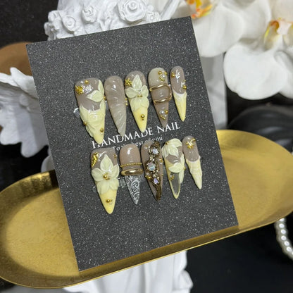 Lifestyle display of taupe butter-yellow and gold NM-A040 Long Stiletto press-on nails