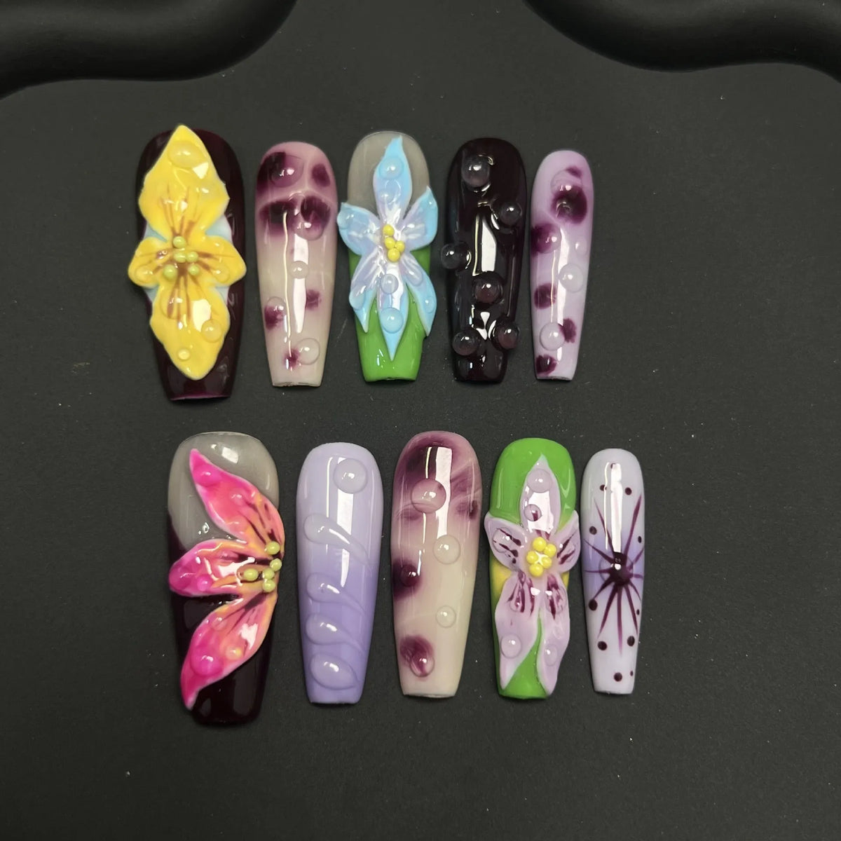 Display view of Chromatic Orchid Dew Medium Coffin nails with multicolor flowers and glassy droplets