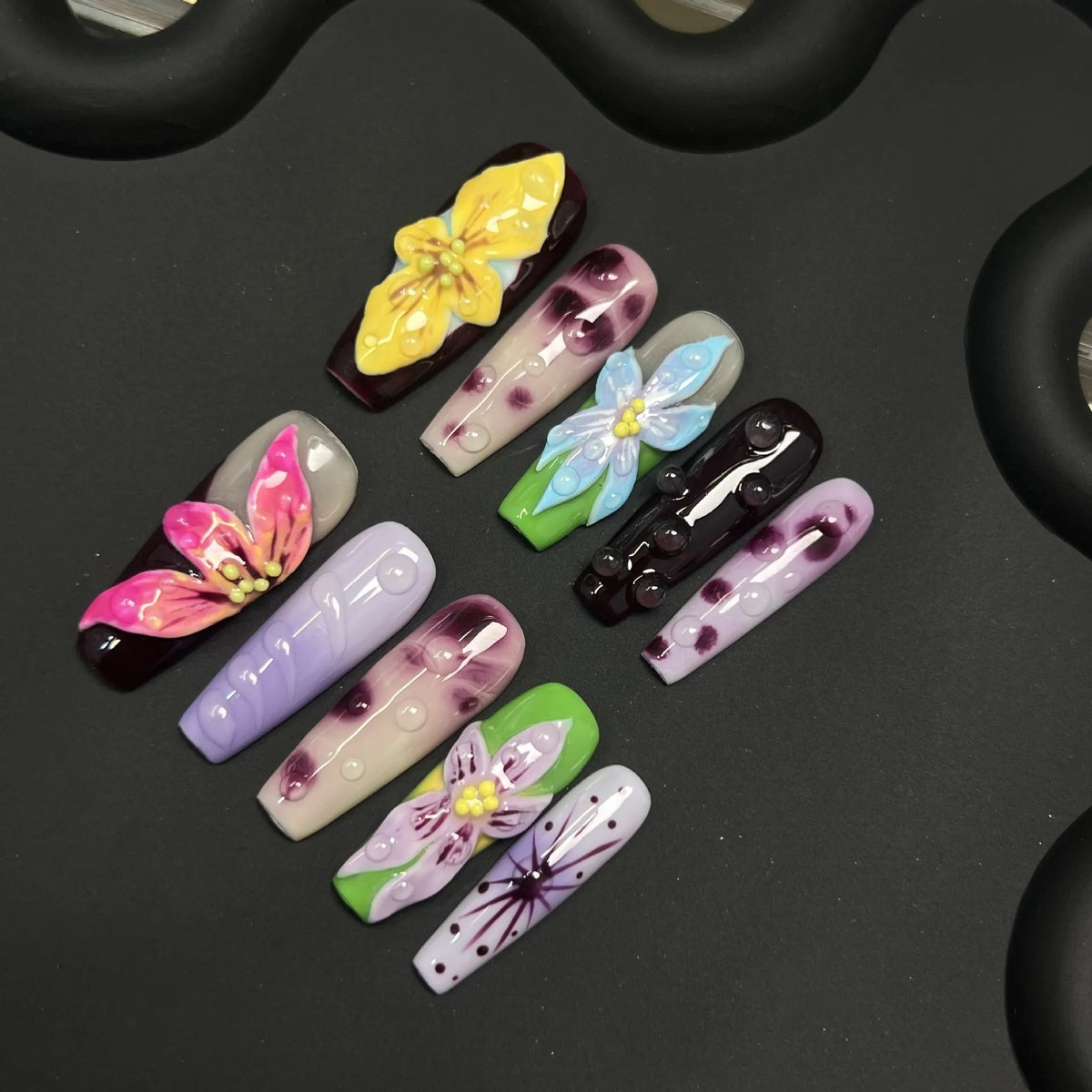 Lifestyle arrangement of NM-A002 Medium Coffin press-on nails with botanical shadows and raised floral texture