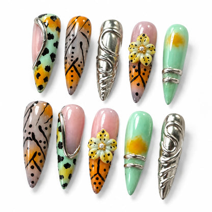 Detailed view of NM-Z189 Long Stiletto nails with sculpted flower silver frames and chrome relief