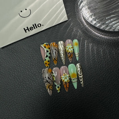 Lifestyle flat lay of mint orange black and silver NM-Z189 Long Stiletto press-on nails