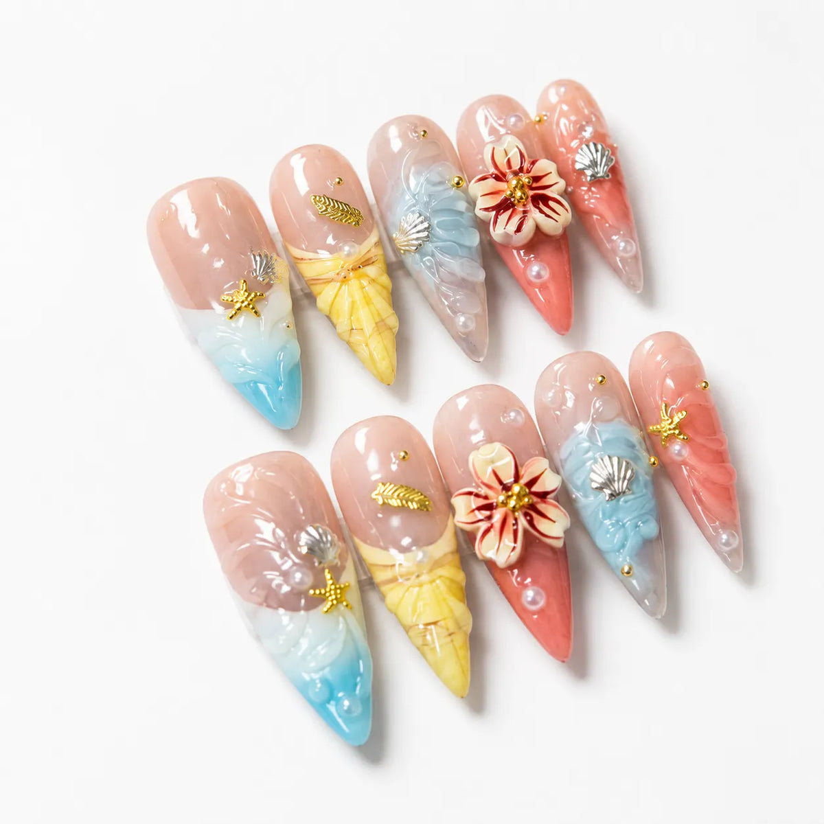 Coastal Bloom Long Stiletto nails arranged on white with aqua, yellow, coral, and nude coastal details