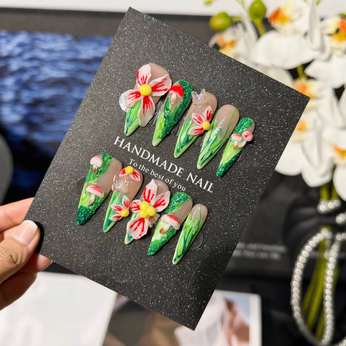 Lifestyle display of green garden Long Stiletto press-on nails with 3D flowers and mushrooms