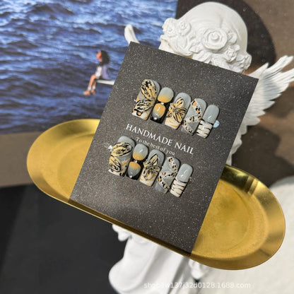 Golden Butterfly Reverie Medium Coffin press-on nails displayed on a handmade nail card