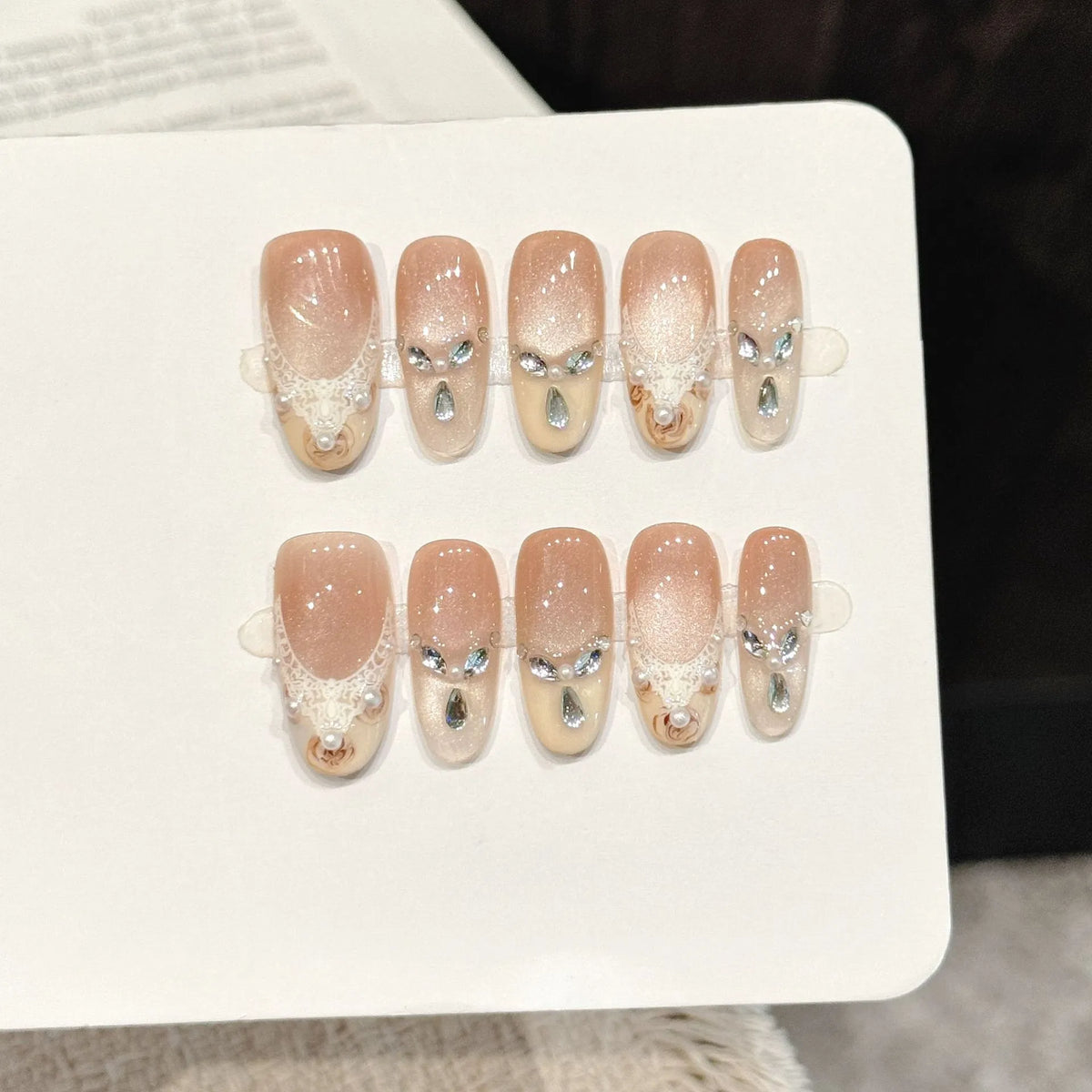 Golden Elegance long oval press-on nails with nude cat eye lace pearl soft luxe design on hand - lifestyle shot 💛✨