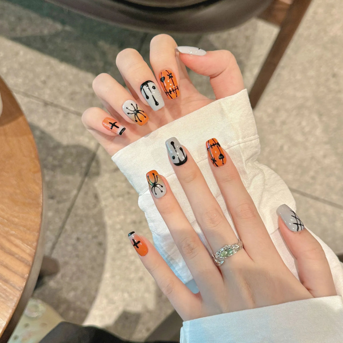 Halloween Stitch Spider short coffin nails shown on hands with spiders, crosses and dripping accents