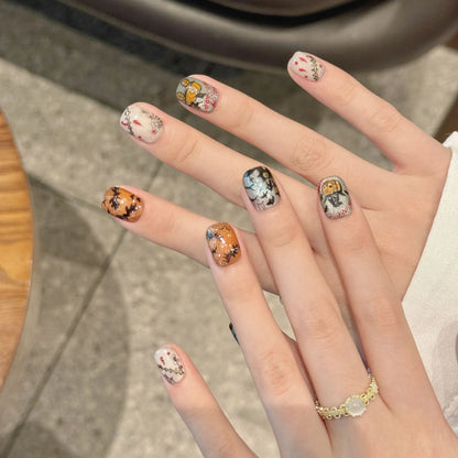 Haunted Moon 2373 Short Oval press-on nails worn on hands with pumpkins, bats, webs, and stitched details
