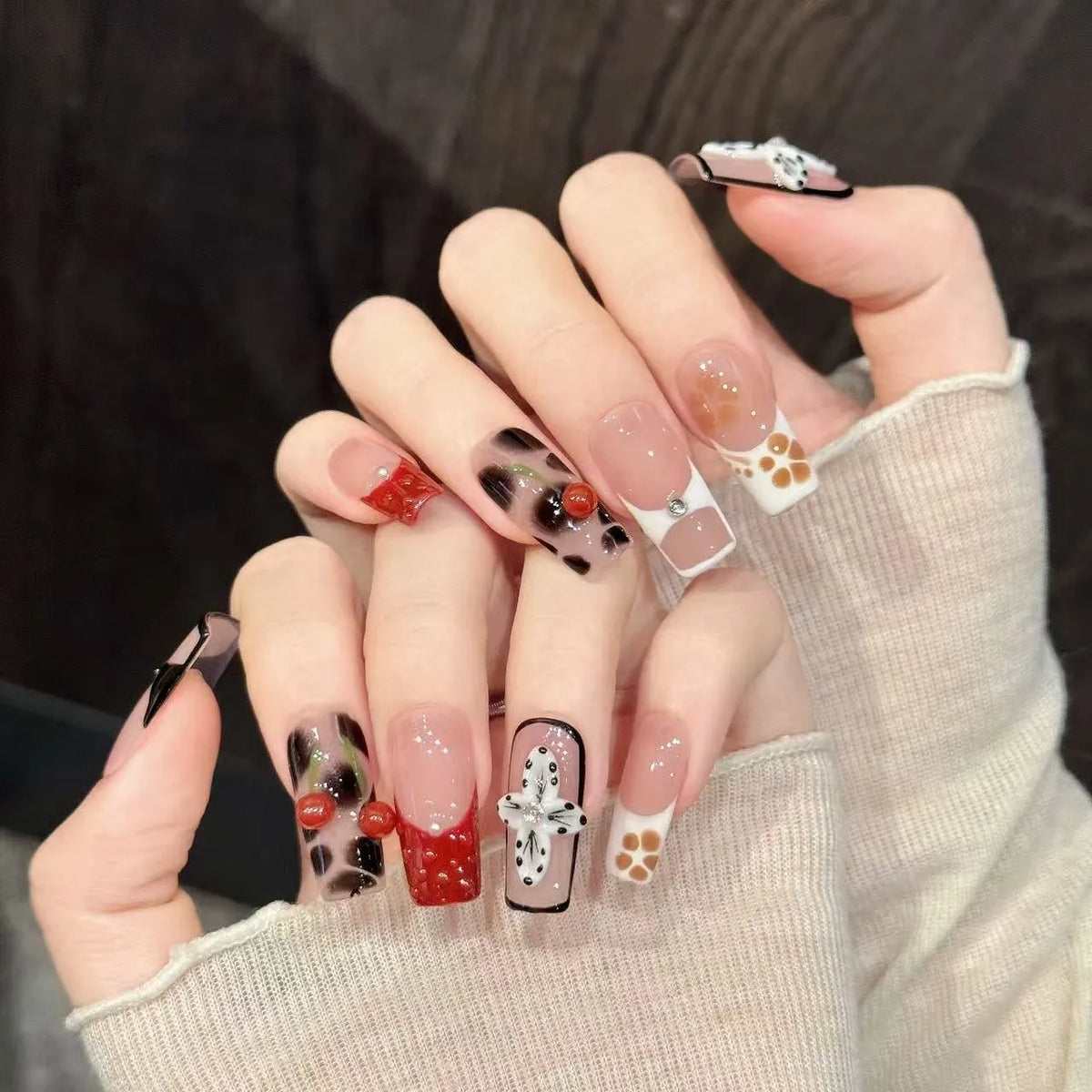 Leopard Cherry Blossom almond nails angled view showing leopard print patterns and 3D cherry accents 🍒