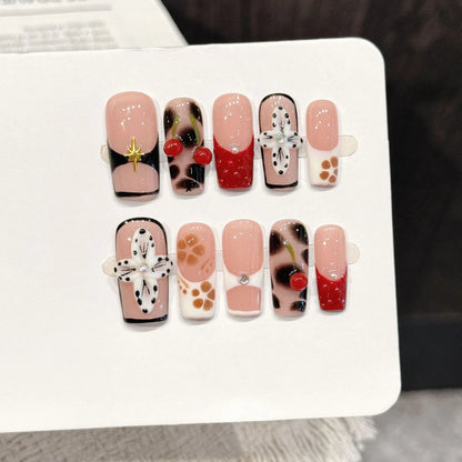 Leopard Cherry Blossom long almond press-on nails with 3D cherry and leopard print design on hand - lifestyle shot 🍒🐆