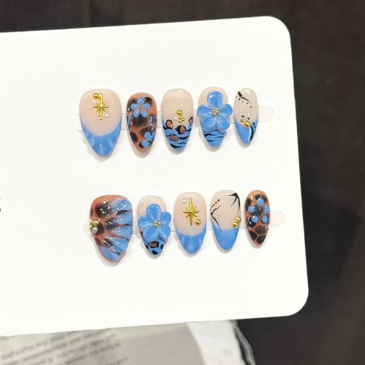 Leopard Lagoon short oval press-on nails with blue floral and leopard print design on hand - lifestyle shot