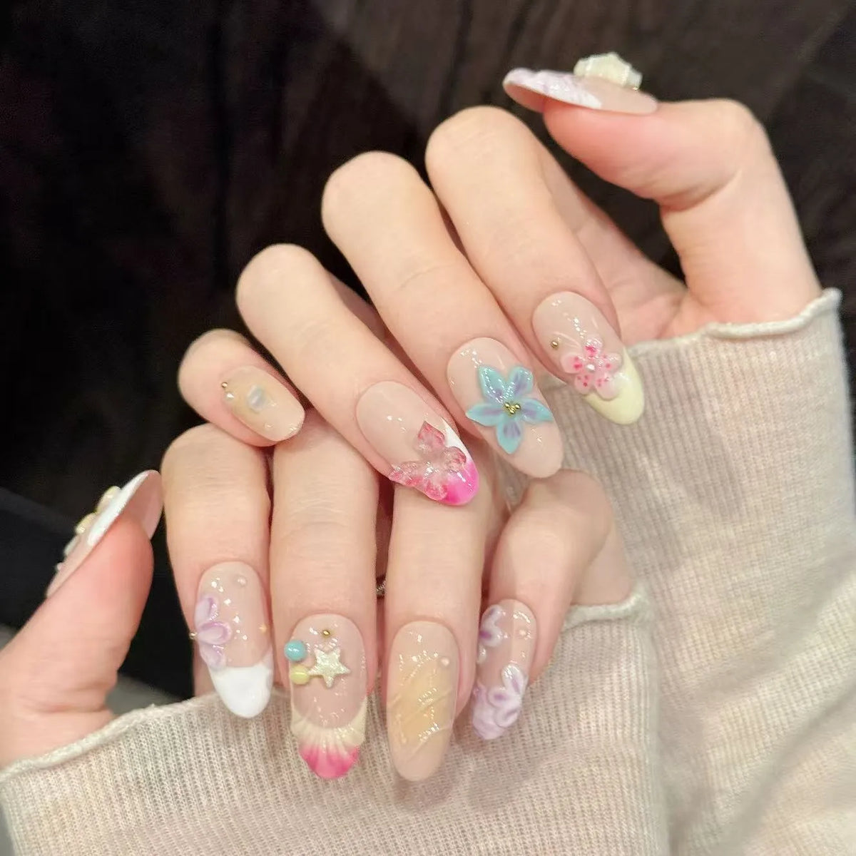 Ocean Shell oval nails angled view showing ocean blue white palette and 3D beach art 🏖️