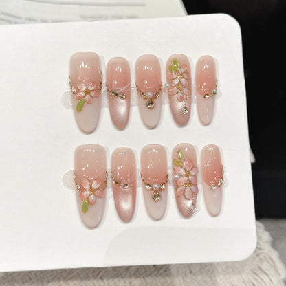 Peach Gold medium stiletto press-on nails with nude pink gold branch rhinestone luxe design on hand - lifestyle shot 🍑✨