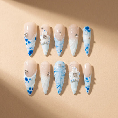 Porcelain Tide 10-piece handmade press-on nail set with blue floral and water ripple designs - product flat lay