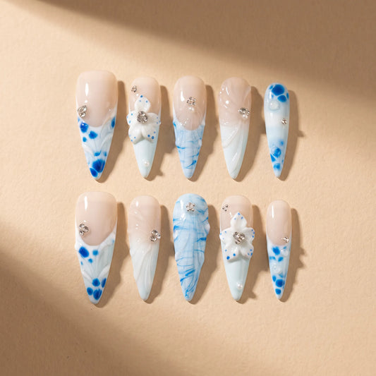 Porcelain Tide 10-piece handmade press-on nail set with blue floral and water ripple designs - product flat lay