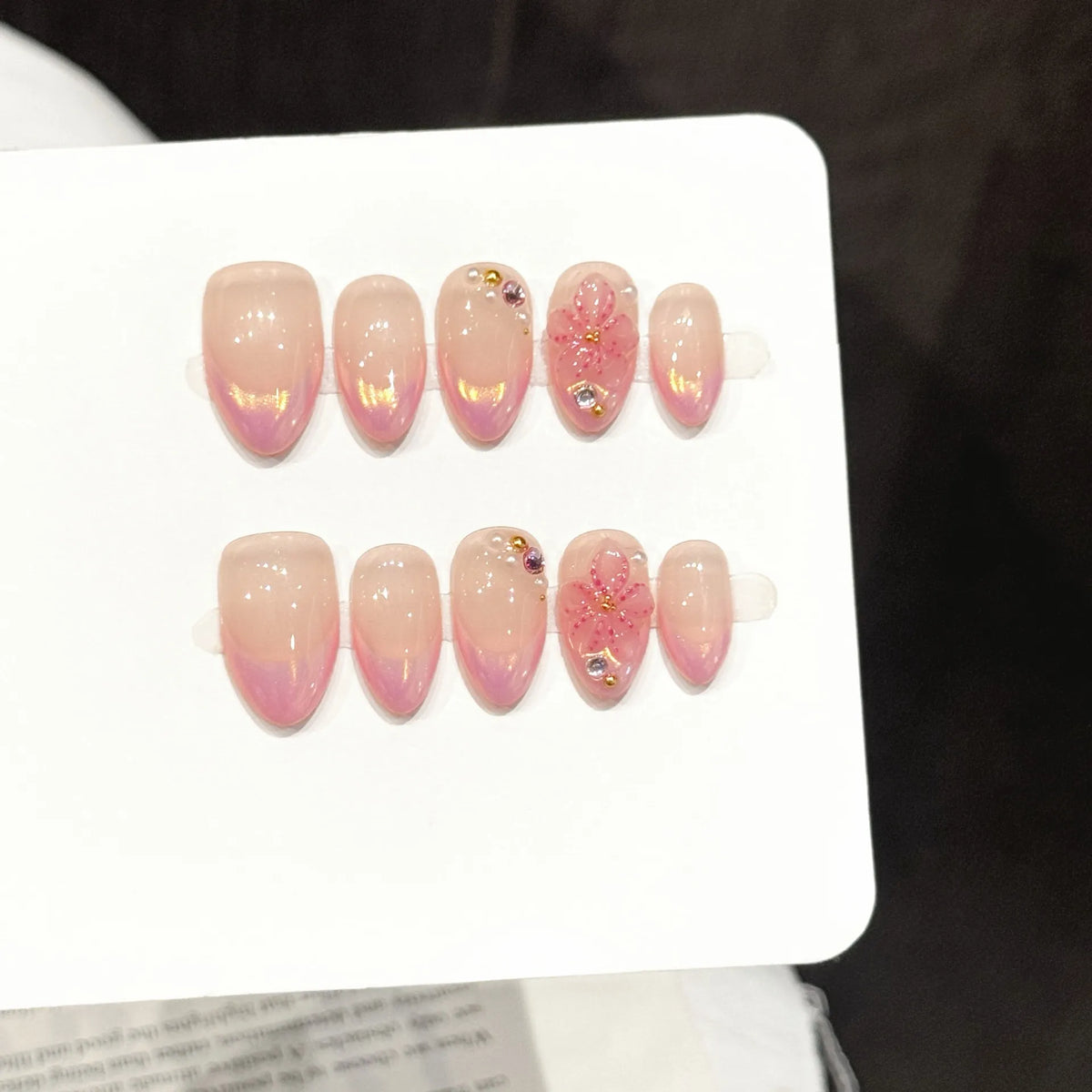 Rose Quartz Glow short oval press-on nails with nude pink French tips and chrome aurora shimmer on hand - lifestyle shot