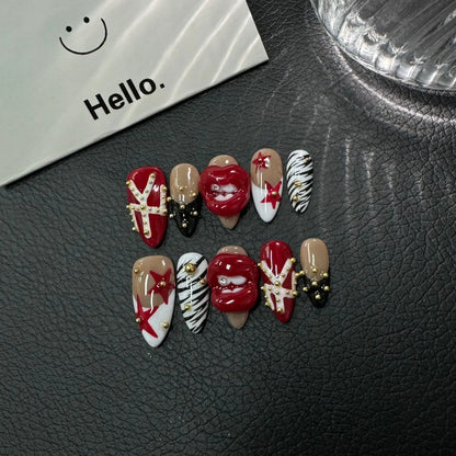 Detailed display of Scarlet Kiss Rebel Medium Almond nails with gold studs crystal tooth and color-block tips