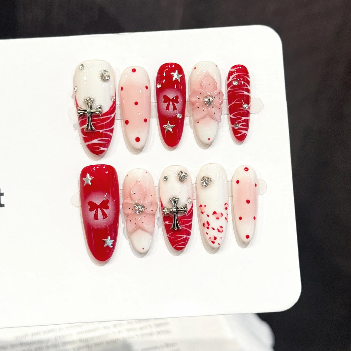 Scarlet Ritual oval nails angled view showing red and white contrast, zebra stripes, and 3D embellishments