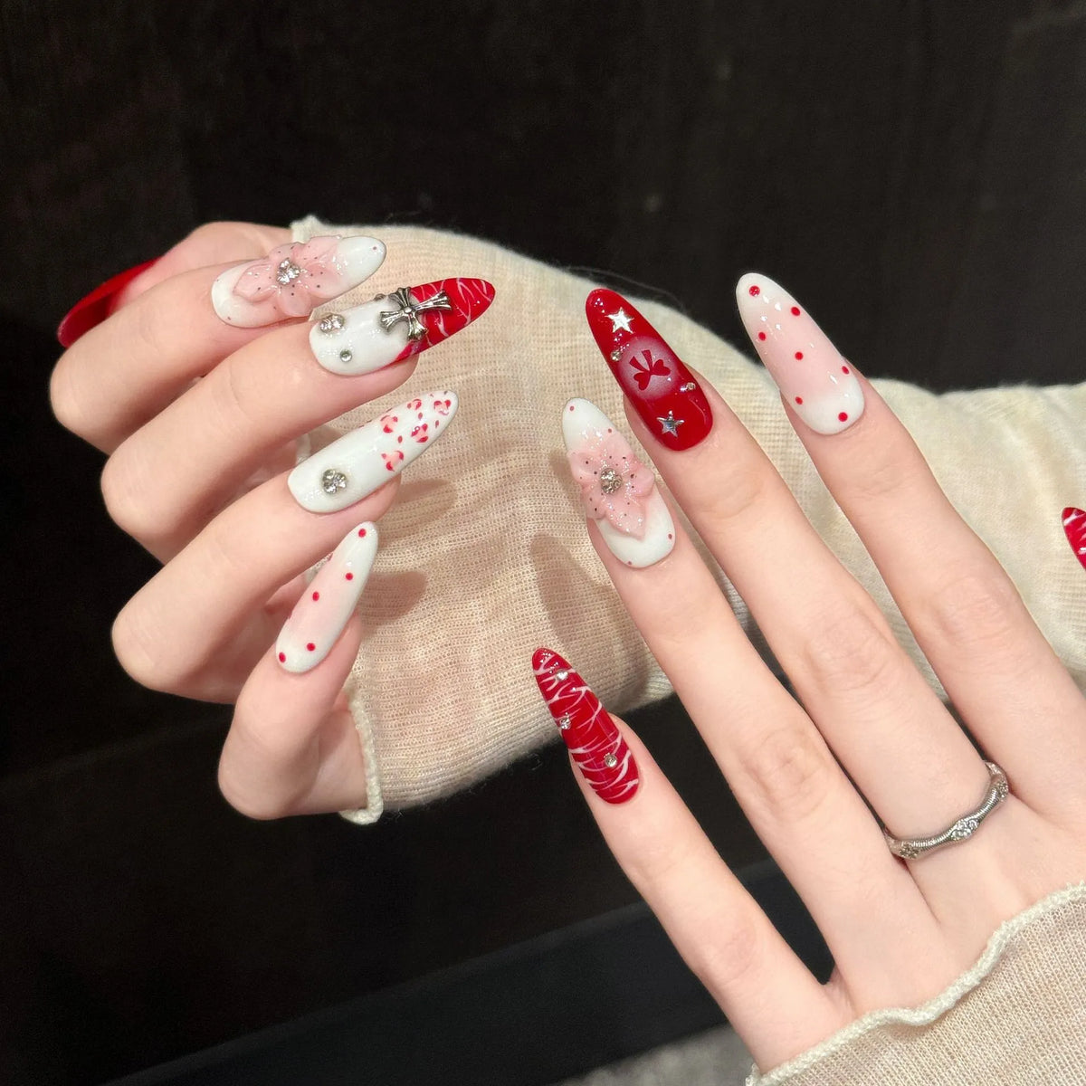 Close-up detail of Scarlet Ritual 3D pink flowers, metal cross charms, red bows and hand-painted art