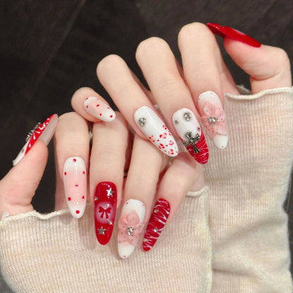 Scarlet Ritual long oval press-on nails with red and white bow Christmas design on hand - lifestyle shot