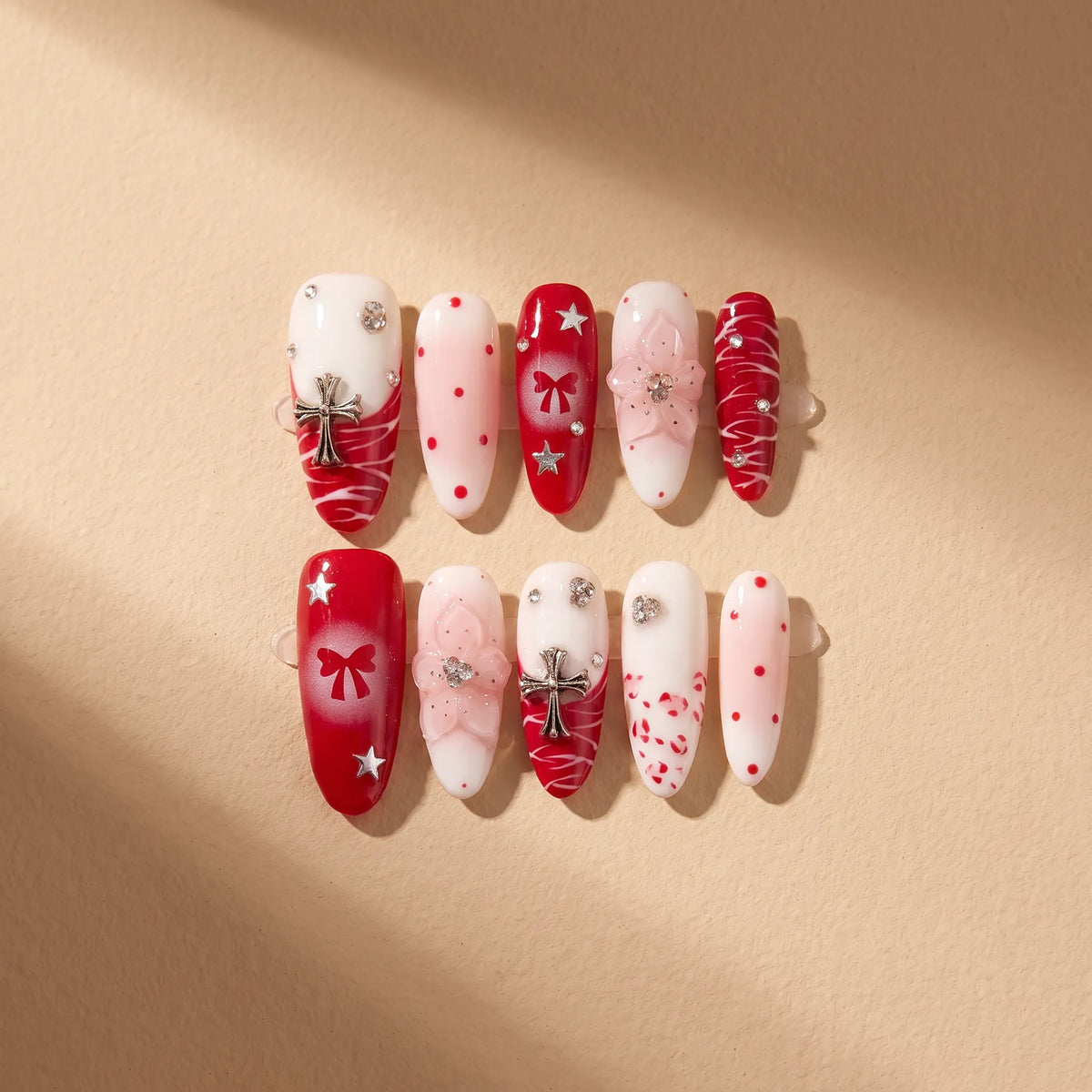 Scarlet Ritual 10-piece handmade press-on nail set with red bow and Christmas designs - product flat lay