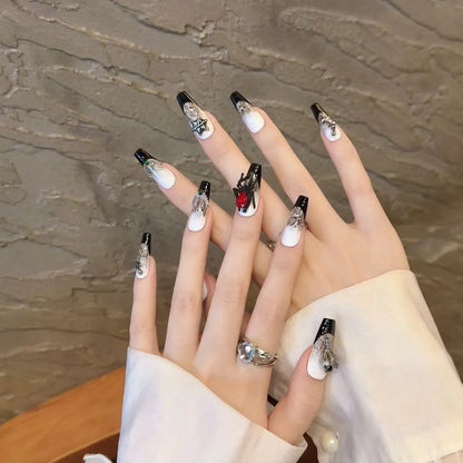 Serpent Blood Jewel gothic snake nails shown on hands with silver charms, red gem and emerald accents