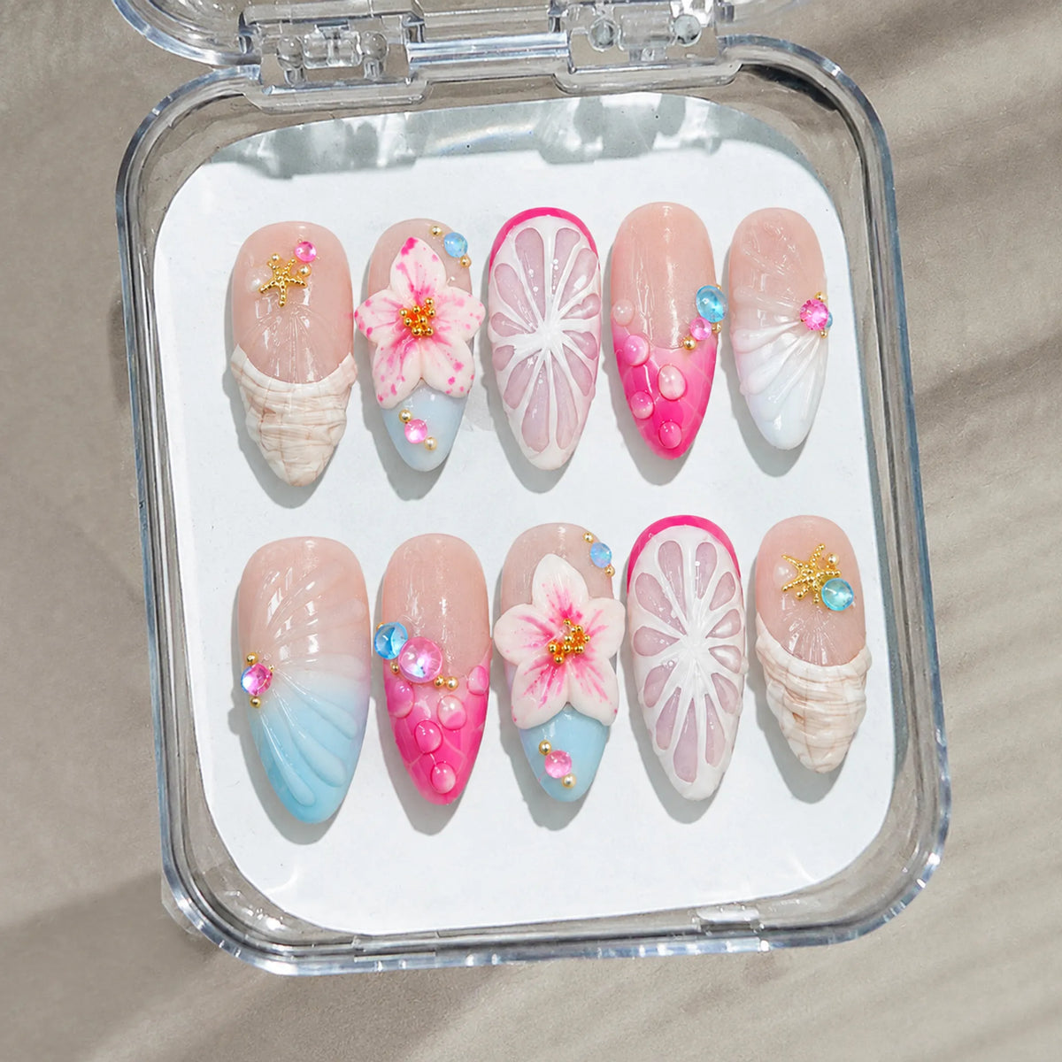 Tropical Shell Blossom handmade Medium Almond nail set arranged in a clear presentation case