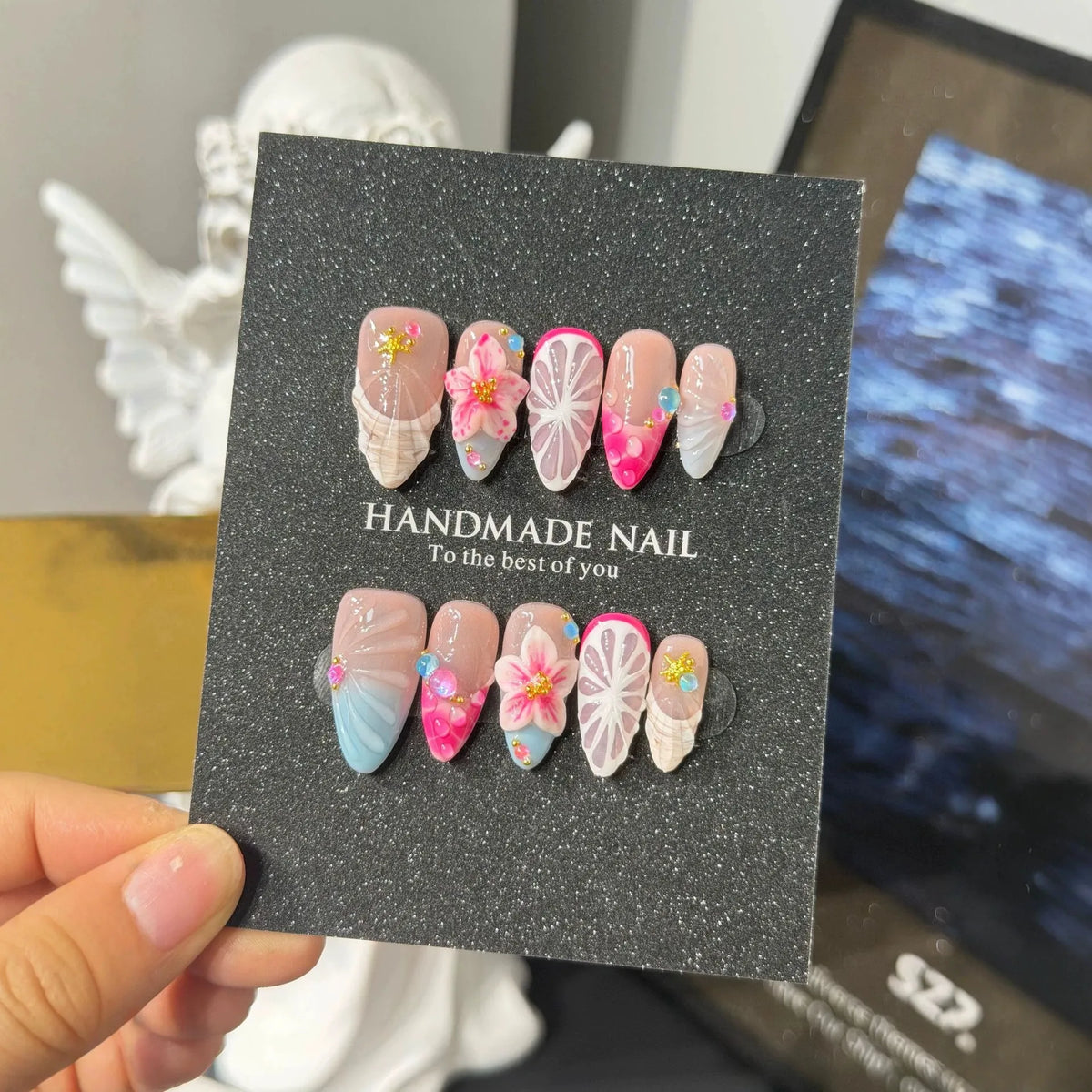 Lifestyle display of pink blue and nude NM-C157 Medium Almond press-on nails